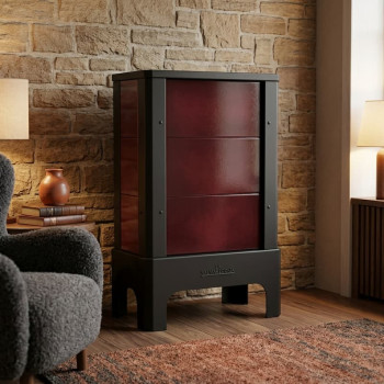 Poêle radiant électrique E30 S La Valmarecchia en céramique bordeaux dans un salon chaleureux