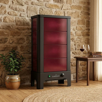 Poêle radiant électrique E40 S La Valmarecchia en céramique bordeaux dans un salon chaleureux