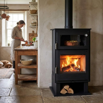 Poêle à bois avec four CH-8 FM installé dans une cuisine, feu allumé dans le foyer et plat en cuisson dans le four