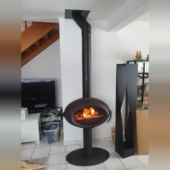 Poêle à bois INVICTA BRIO sur pied dans un séjour carrelé, avec range-bûches